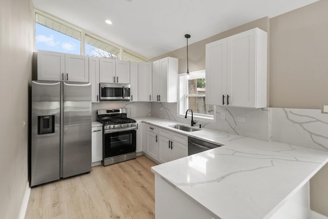 15224 Oak St, Dolton, IL 60419 - kitchen featuring stainless steel appliances, a peninsula, light wood-type flooring, light stone countertops, and lofted ceiling