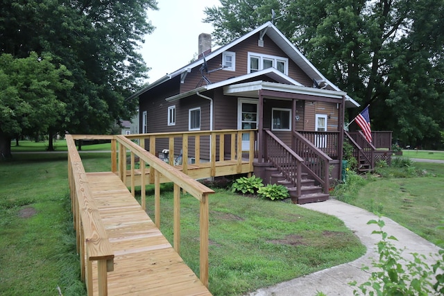 105 Bradley St, New Bedford, IL 61346 - view of front facade featuring a chimney, stairway, a front yard, and a deck