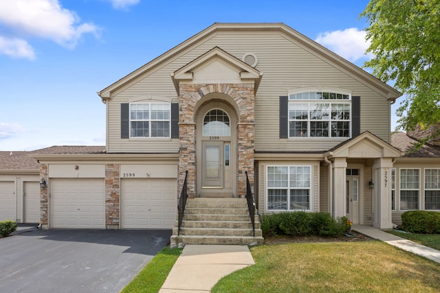 2599 Oak Dr Unit 2599, West Dundee, IL 60118 - traditional home with asphalt driveway, stone siding, a front yard, an attached garage, and a shingled roof