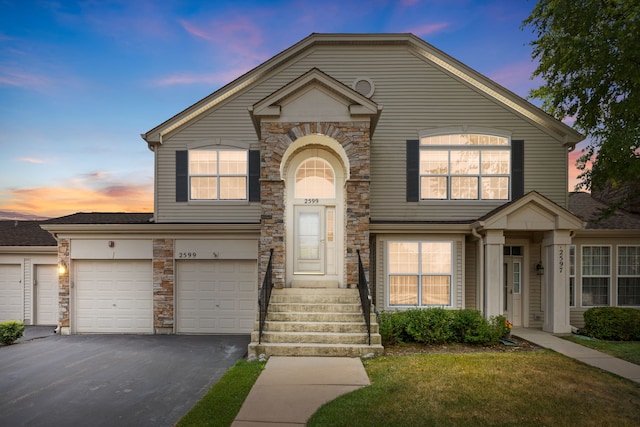 2599 Oak Dr Unit 2599, West Dundee, IL 60118 - traditional home with stone siding, asphalt driveway, and a lawn