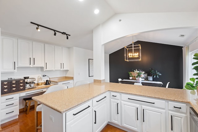 2599 Oak Dr Unit 2599, West Dundee, IL 60118 - kitchen featuring rail lighting, a chandelier, white cabinets, light wood-type flooring, and vaulted ceiling