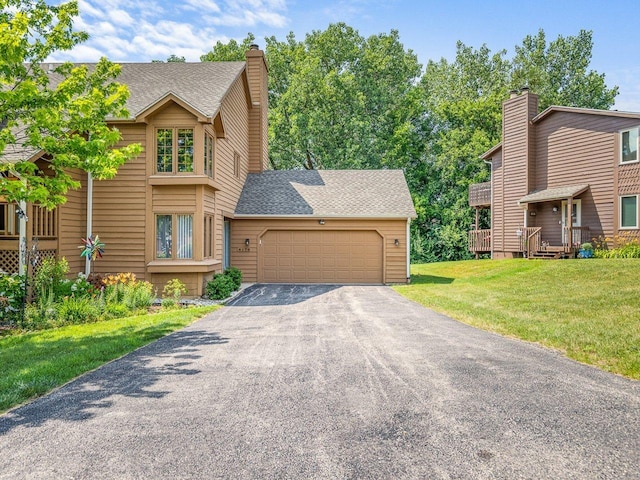 4176 Tumbleweed Trl Unit 0, Loves Park, IL 61111 - view of front of home with driveway, a chimney, an attached garage, and a front lawn