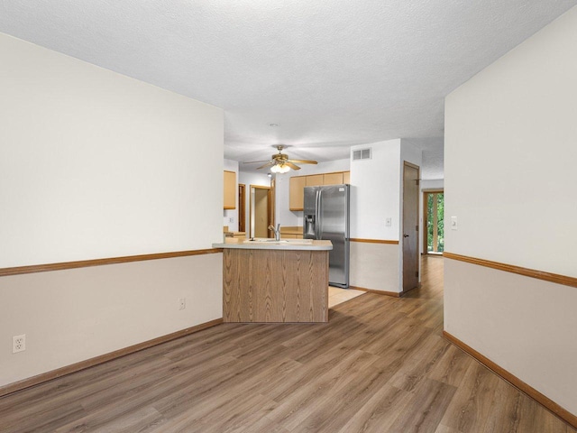 4176 Tumbleweed Trl Unit 0, Loves Park, IL 61111 - kitchen featuring stainless steel fridge, a peninsula, light wood-style floors, a ceiling fan, and light countertops
