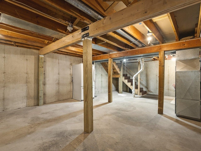4176 Tumbleweed Trl Unit 0, Loves Park, IL 61111 - unfinished basement with freestanding refrigerator, stairway, and heating unit