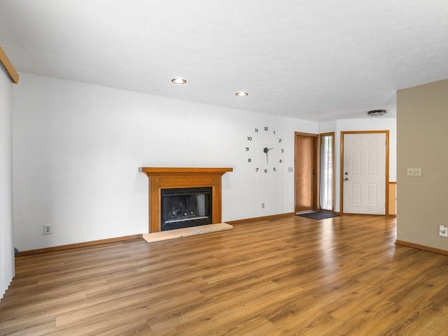 4176 Tumbleweed Trl Unit 0, Loves Park, IL 61111 - unfurnished living room featuring light wood finished floors, a fireplace with raised hearth, and recessed lighting