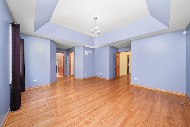 6443 Davane Ct, Downers Grove, IL 60516 - empty room featuring a raised ceiling, light wood finished floors, and a chandelier