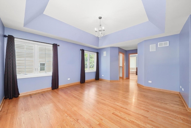 6443 Davane Ct, Downers Grove, IL 60516 - unfurnished room with a tray ceiling, a chandelier, and light wood-style flooring