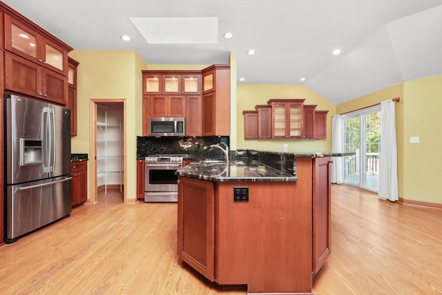 6443 Davane Ct, Downers Grove, IL 60516 - kitchen featuring appliances with stainless steel finishes, a skylight, light wood-style flooring, glass insert cabinets, and vaulted ceiling