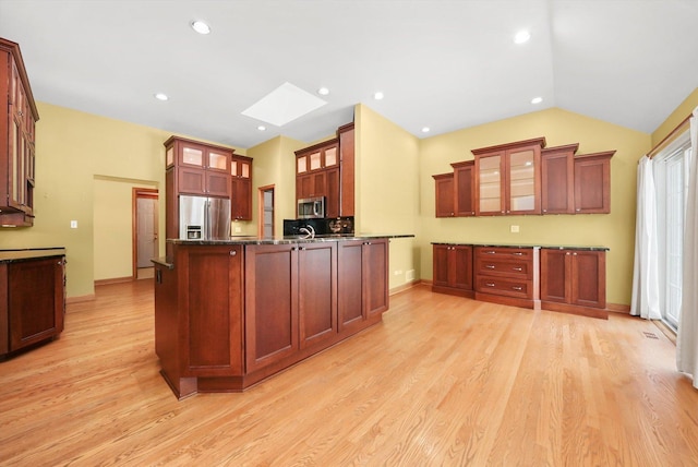 6443 Davane Ct, Downers Grove, IL 60516 - kitchen with appliances with stainless steel finishes, a skylight, glass insert cabinets, light wood-style floors, and a peninsula