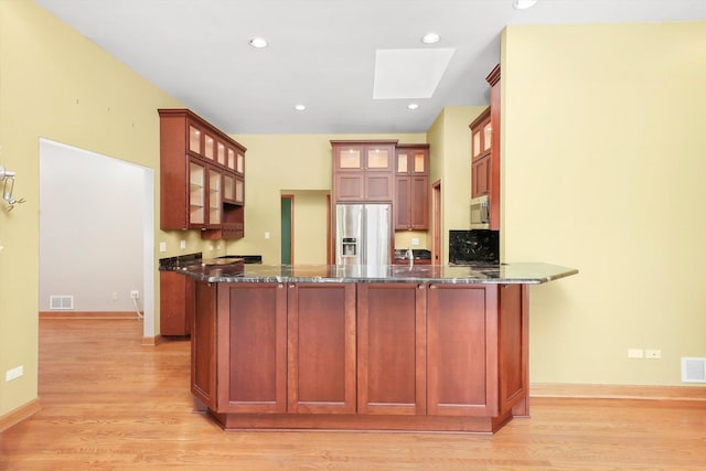 6443 Davane Ct, Downers Grove, IL 60516 - kitchen with stainless steel appliances, dark stone counters, a skylight, a peninsula, and recessed lighting