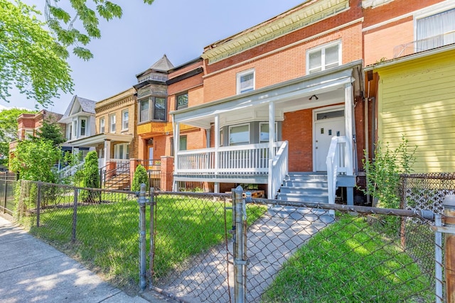 1310 E 72nd St, Chicago, IL 60619 - view of property with covered porch, brick siding, a fenced front yard, and a gate