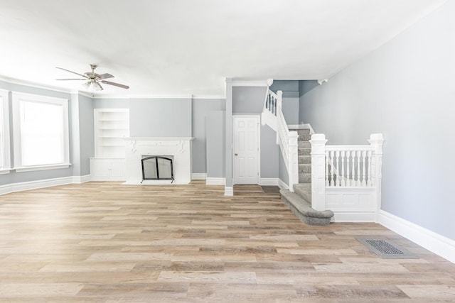 1310 E 72nd St, Chicago, IL 60619 - unfurnished living room featuring ceiling fan, light wood-type flooring, built in features, and stairs