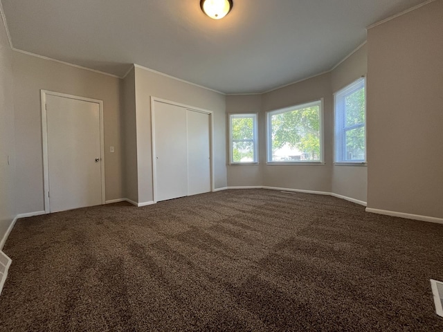 205 N Chicago St, Magnolia, IL 61336 - unfurnished bedroom featuring ornamental molding, dark colored carpet, and a closet