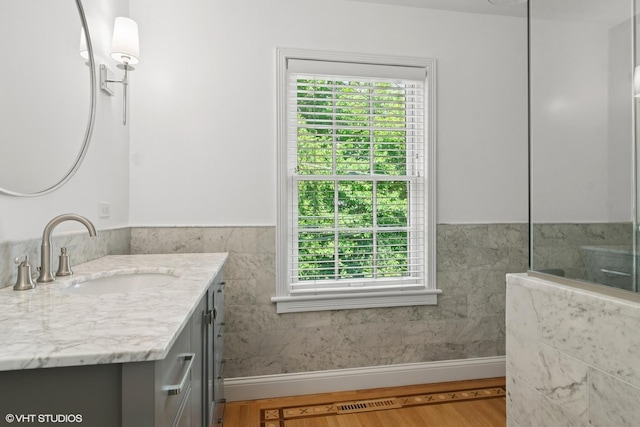 500 E Mayfair Rd, Arlington Heights, IL 60005 - bathroom with vanity, plenty of natural light, a wainscoted wall, wood finished floors, and tile walls