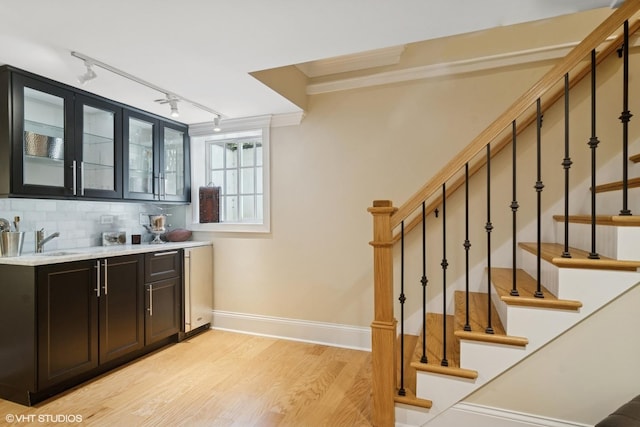 500 E Mayfair Rd, Arlington Heights, IL 60005 - indoor bar featuring track lighting, light wood finished floors, crown molding, decorative backsplash, and stairway