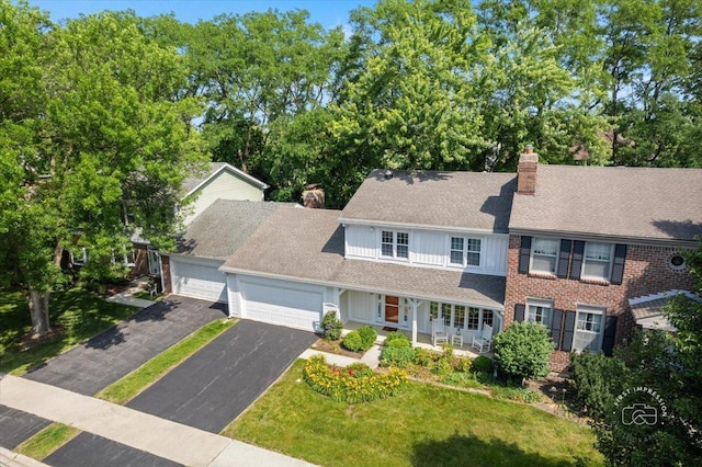 1519 Wedgefield Cir, Naperville, IL 60563 - view of front of property with a chimney, a garage, asphalt driveway, covered porch, and a front lawn