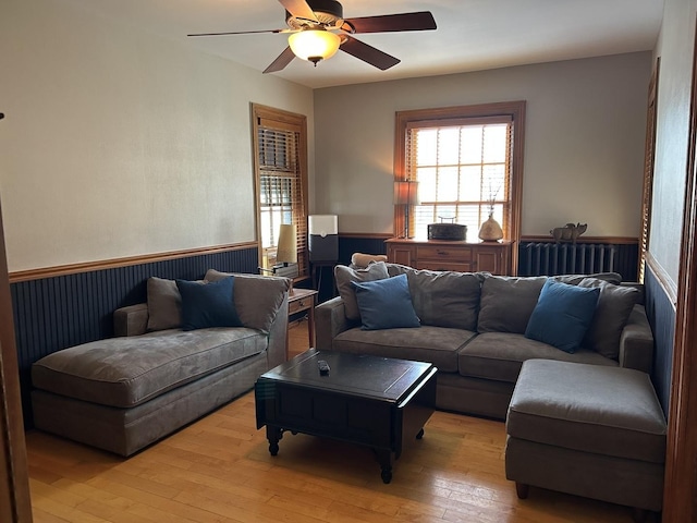 7246 N Oleander Ave, Chicago, IL 60631 - living area with radiator, wainscoting, light wood finished floors, and ceiling fan