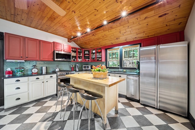 7246 N Oleander Ave, Chicago, IL 60631 - kitchen with stainless steel appliances, dark floors, wood counters, vaulted ceiling, and tasteful backsplash