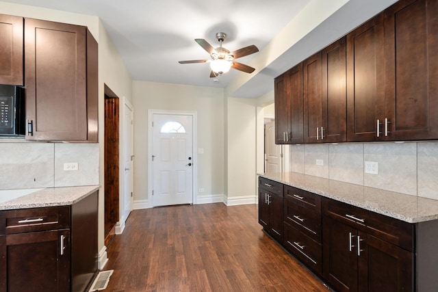 12300 Maple Ave, Blue Island, IL 60406 - kitchen featuring ceiling fan, dark wood-style flooring, backsplash, light stone counters, and black microwave