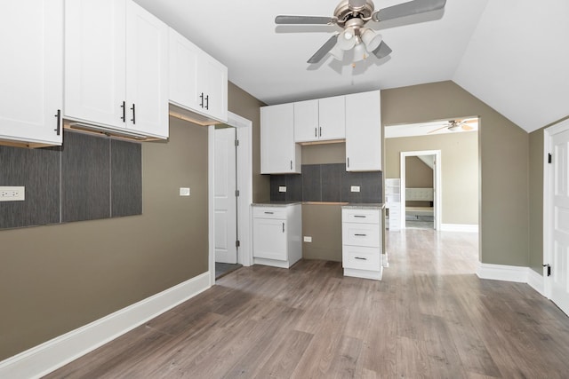 12300 Maple Ave, Blue Island, IL 60406 - kitchen with a ceiling fan, decorative backsplash, wood finished floors, white cabinetry, and lofted ceiling