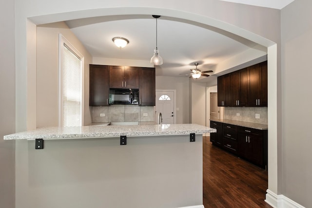 12300 Maple Ave, Blue Island, IL 60406 - kitchen with black microwave, tasteful backsplash, dark brown cabinetry, and ceiling fan