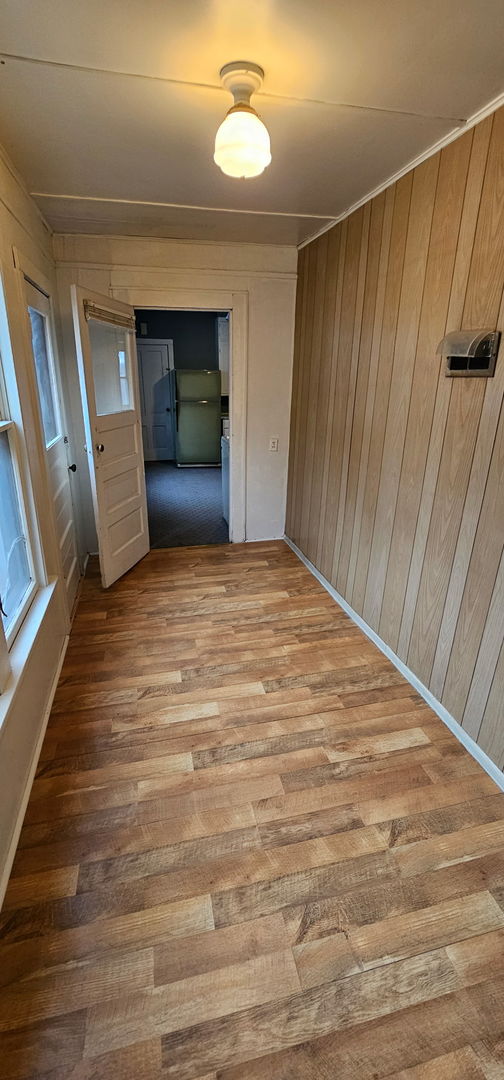 24 Mulberry St, Savanna, IL 61074 - empty room with wood finished floors and wooden walls