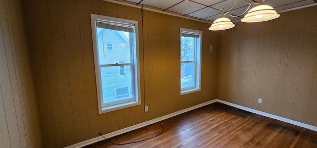24 Mulberry St, Savanna, IL 61074 - empty room featuring dark wood finished floors, wooden walls, and a chandelier