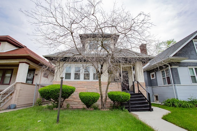 1318 N Menard Ave, Chicago, IL 60651 - view of front facade featuring stone siding, a front yard, a porch, and a chimney
