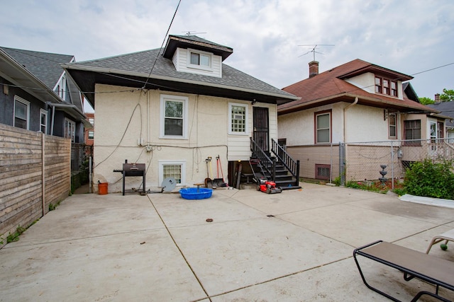 1318 N Menard Ave, Chicago, IL 60651 - back of property with stucco siding, a fenced backyard, a patio area, and roof with shingles