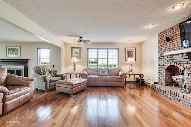 10766 E 7000n Rd, Grant Park, IL 60940 - living room featuring a fireplace, plenty of natural light, a ceiling fan, a textured ceiling, and hardwood / wood-style flooring