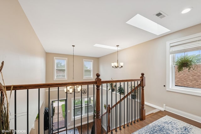 3109 N Oketo Ave, Chicago, IL 60707 - corridor featuring a chandelier, an upstairs landing, a skylight, and wood finished floors
