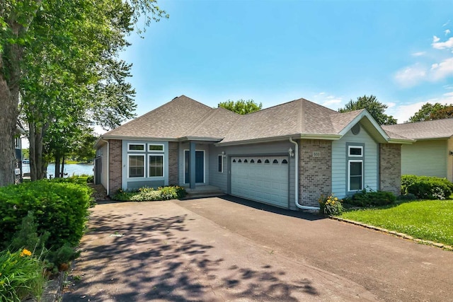 930 Candlewick Dr NE, Poplar Grove, IL 61065 - view of front of home with brick siding, an attached garage, driveway, and a shingled roof