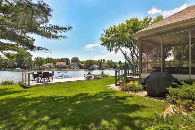 930 Candlewick Dr NE, Poplar Grove, IL 61065 - view of green lawn with a sunroom, ceiling fan, and a deck with water view