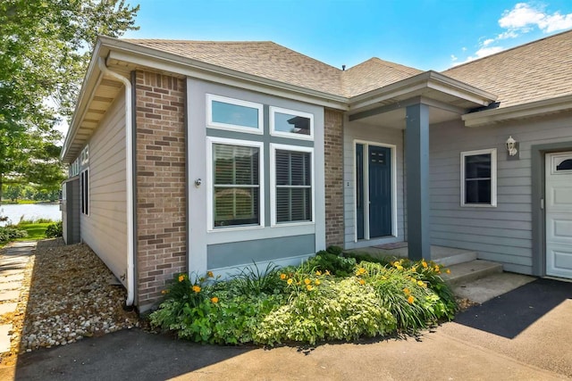 930 Candlewick Dr NE, Poplar Grove, IL 61065 - property entrance with brick siding and a shingled roof