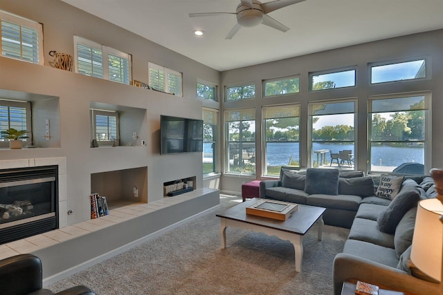 930 Candlewick Dr NE, Poplar Grove, IL 61065 - carpeted living area with a tiled fireplace, a ceiling fan, recessed lighting, and a high ceiling