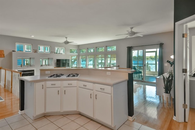 930 Candlewick Dr NE, Poplar Grove, IL 61065 - kitchen with a ceiling fan, open floor plan, light countertops, white cabinetry, and white gas stovetop
