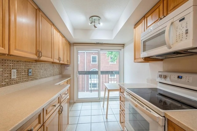 1738 Chicago Ave Unit 303, Evanston, IL 60201 - kitchen featuring white appliances, a tray ceiling, backsplash, and light countertops