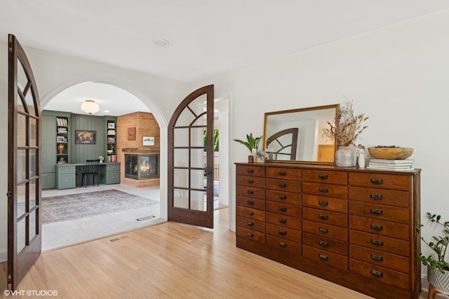 1 E Milburn Ave, Mount Prospect, IL 60056 - foyer entrance featuring french doors, wood finished floors, a brick fireplace, and arched walkways