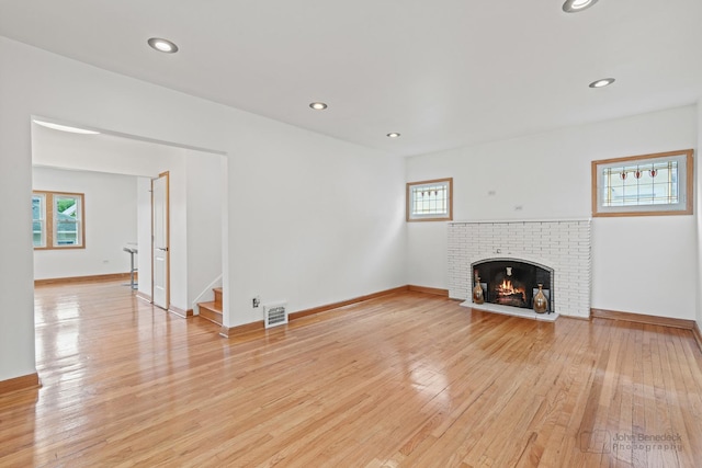 619 N 4th Ave, Maywood, IL 60153 - unfurnished living room with plenty of natural light, light wood-style flooring, a fireplace, stairs, and recessed lighting
