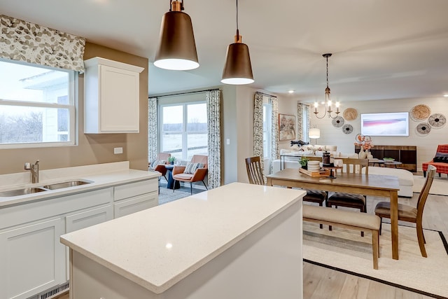 458 Bower Ln, Oswego, IL 60543 - kitchen featuring light wood finished floors, a chandelier, a center island, and light countertops