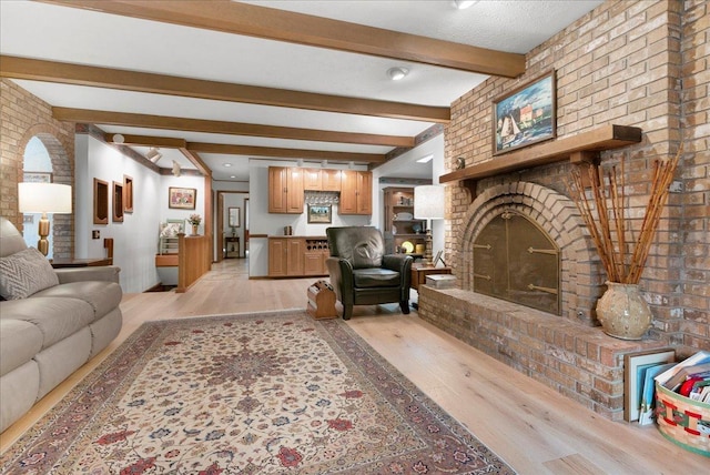 25316 E 1100 N Rd, Downs, IL 61736 - living room with light wood finished floors, beamed ceiling, brick wall, and a fireplace