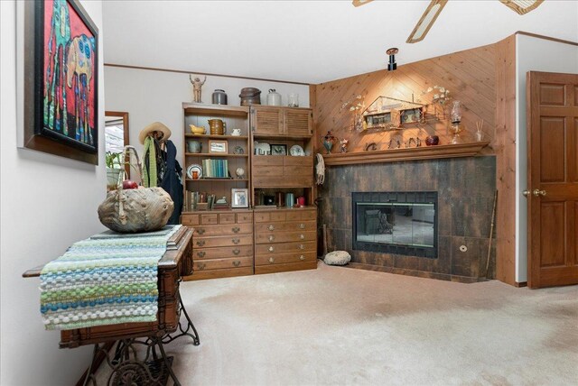 25316 E 1100 N Rd, Downs, IL 61736 - living room with carpet flooring, a tiled fireplace, wood walls, and a ceiling fan