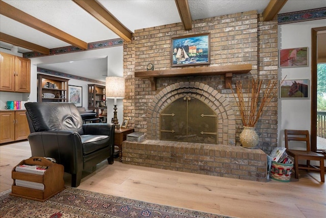 25316 E 1100 N Rd, Downs, IL 61736 - living area featuring a brick fireplace, light wood finished floors, and beam ceiling