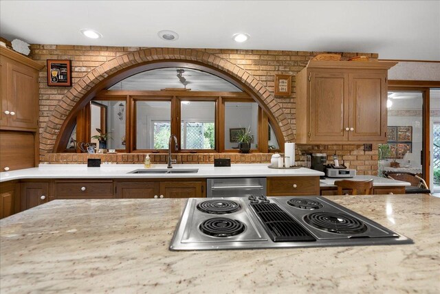 25316 E 1100 N Rd, Downs, IL 61736 - kitchen with stainless steel appliances, arched walkways, light stone countertops, and brown cabinetry