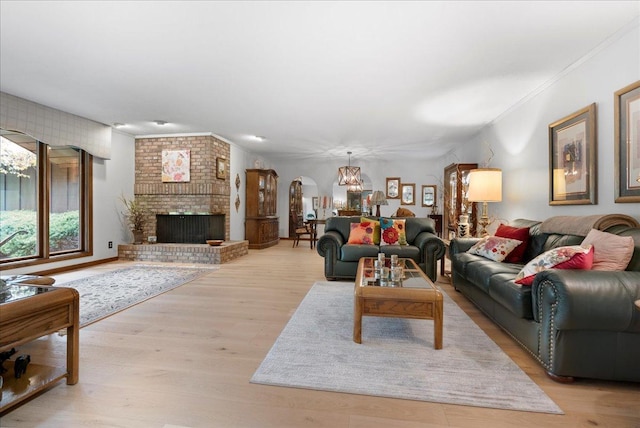 25316 E 1100 N Rd, Downs, IL 61736 - living room with wood finished floors, ornamental molding, a chandelier, arched walkways, and a fireplace