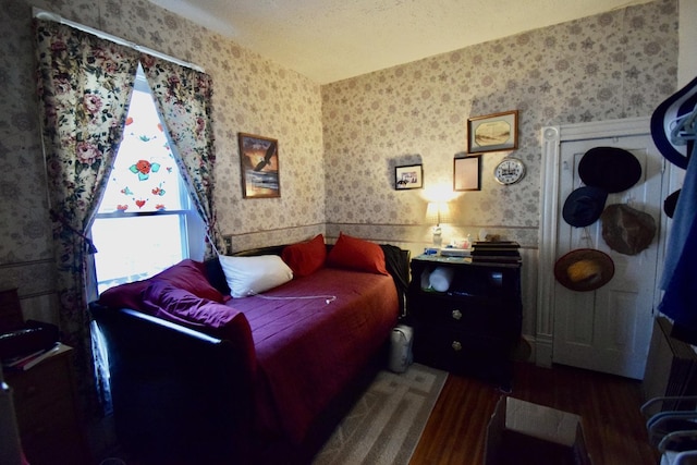 915 W Olive St, Bloomington, IL 61701 - bedroom with wallpapered walls, wood finished floors, and a wainscoted wall