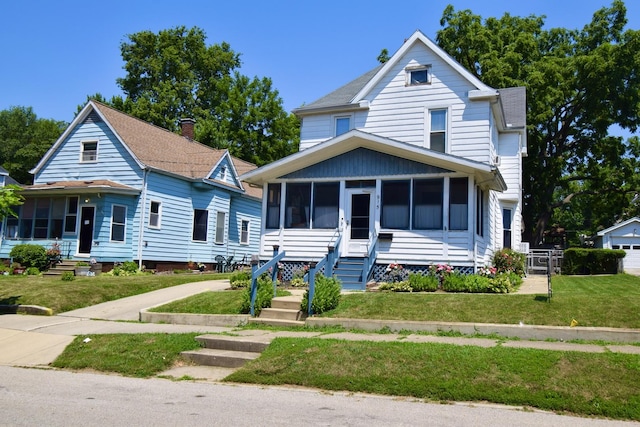 915 W Olive St, Bloomington, IL 61701 - view of front facade with a sunroom, entry steps, and a front lawn
