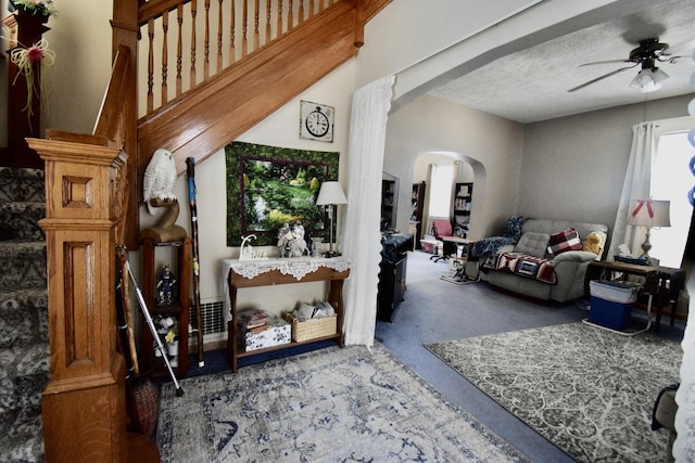 915 W Olive St, Bloomington, IL 61701 - living area featuring arched walkways, ceiling fan, carpet, and a textured ceiling