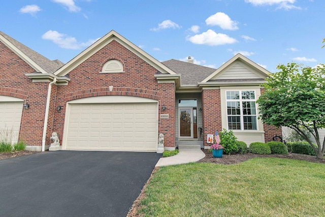 4100 Coyote Lakes Cir, Lake In The Hills, IL 60156 - view of front of property featuring asphalt driveway, brick siding, a front yard, roof with shingles, and a garage