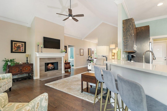 4100 Coyote Lakes Cir, Lake In The Hills, IL 60156 - living area featuring ceiling fan, dark wood-style flooring, a tiled fireplace, ornamental molding, and vaulted ceiling